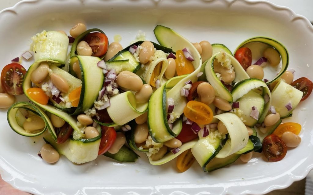 Butter bean and courgette salad on a white platter